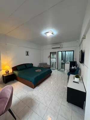 a bedroom with a green bed and a living room at Hana apartment in Patong Beach