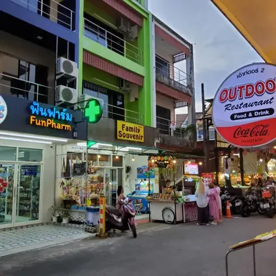 a group of people standing in front of a building at Flowernight Guesthouse in Kata Beach