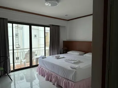 a bedroom with a large bed and a balcony at Flowernight Guesthouse in Kata Beach