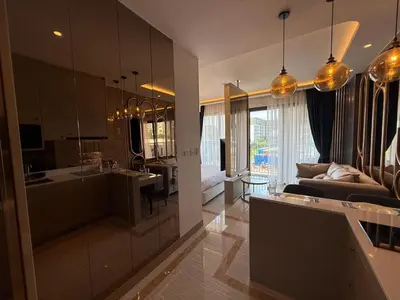 a kitchen and living room with a couch and a table at New studio of Bangtao Bellevue Lagoon 213 in Laguna Phuket