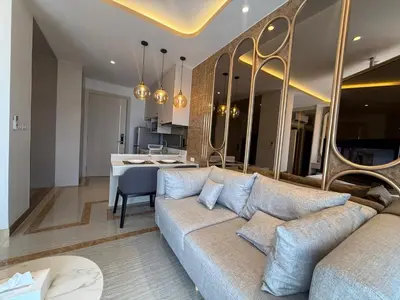 a living room with a couch and a kitchen at New studio of Bangtao Bellevue Lagoon 213 in Laguna Phuket