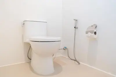 a white toilet in a bathroom with a roll of toilet paper at Stylish Studio with Pool - 8' walk to Rawai Beach - 