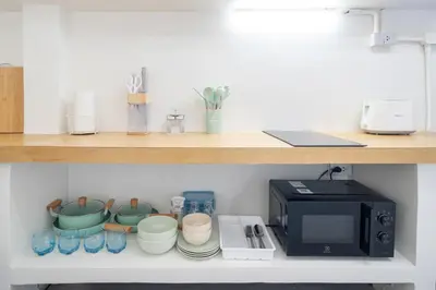 a shelf with a microwave and some cups and plates at Stylish Studio with Pool - 8' walk to Rawai Beach - 