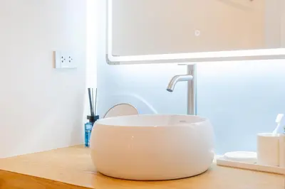 a white bowl sitting on a table next to a lamp at Stylish Studio with Pool - 8' walk to Rawai Beach - 