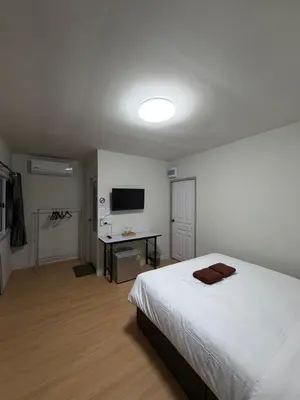 a bedroom with a white bed and a television at Greenview Room and Restaurant