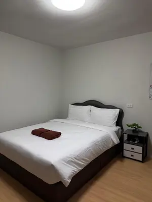 a bedroom with a white bed with a brown towel on it at Greenview Room and Restaurant