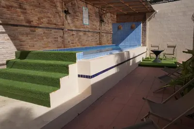 a swimming pool with stairs and green grass at Residy Downtown Hotel in Patong Beach