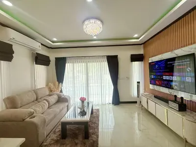 a living room with a couch and a flat screen tv at PS House Bangtao in Bang Tao Beach