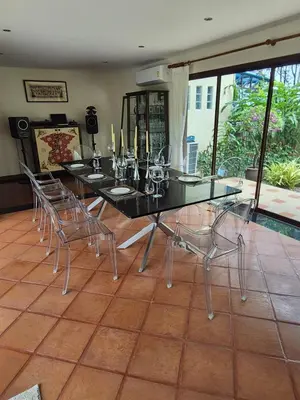 a dining room with a black table and chairs at 5BR Luxury Villa Bangtao With Staff Phuket in Laguna Phuket