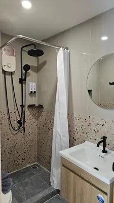 a bathroom with a shower and a sink and a mirror at CK House in Patong Beach