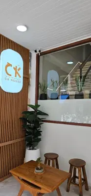 a table and stools in a room with a cst house sign at CK House in Patong Beach