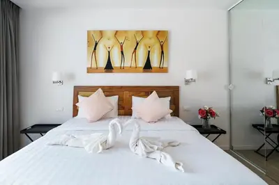 a bedroom with a bed with white towels on it at Tilawan Villa by G Estate Phuket in Ban Klang