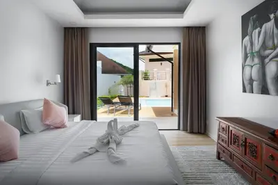 a bedroom with a bed and a sliding glass door at Tilawan Villa by G Estate Phuket in Ban Klang