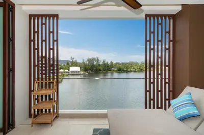 a room with a large window with a view of the water at Luxury 2BR Suite Lakeside Angsana Laguna in Phuket Town