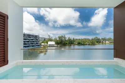 a swimming pool with a view of a body of water at Luxury 2BR Suite Lakeside Angsana Laguna in Phuket Town