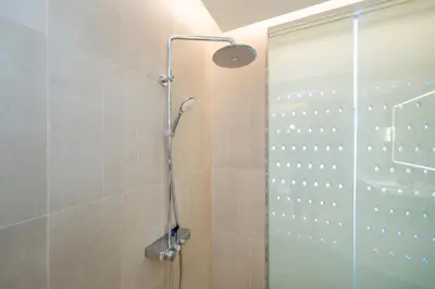 a shower with a glass door in a bathroom at Luxury 2BR Suite Lakeside Angsana Laguna in Phuket Town