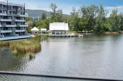 a view of a lake with a building next to a building at Luxury 2BR Suite Lakeside Angsana Laguna in Phuket Town