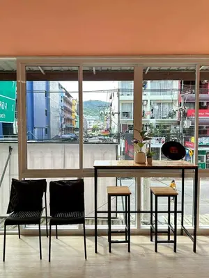 a table and chairs in a room with a large window at Jellyfish Residence Patong in Patong Beach