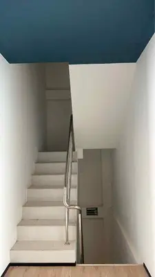 a staircase in a building with white stairs and blue ceilings at Jellyfish Residence Patong in Patong Beach