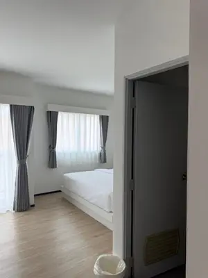 a white bedroom with a bed and a mirror at Jellyfish Residence Patong in Patong Beach