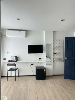 a living room with a tv and a chair at Jellyfish Residence Patong in Patong Beach