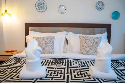 a bedroom with a bed with white stockings on it at Nyonya Maison Boutique Hotel Phuket Old Town in Phuket Town