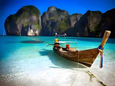 a boat on a beach in the water at XX GO INN Patong Beach Phuket - โกอินน์ ป่าตอง in Patong Beach