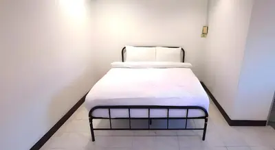 a bed with white sheets and pillows in a room at XX GO INN Patong Beach Phuket - โกอินน์ ป่าตอง in Patong Beach