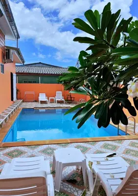 a pool with chairs and a palm tree next to a house at Chalong pool villa in Ban Na Bon
