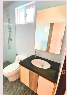 a bathroom with a sink and a toilet and a mirror at Chalong pool villa in Ban Na Bon
