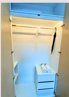a white closet with two towels on a shelf at Chalong pool villa in Ban Na Bon