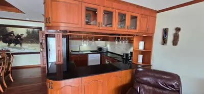 a kitchen with wooden cabinets and a black counter top at PATONG TOWER Luxury Large Apartments in Patong Beach