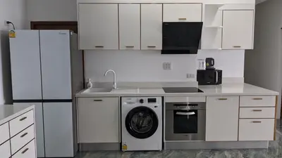 a kitchen with white cabinets and a washing machine at PATONG TOWER Luxury Large Apartments in Patong Beach