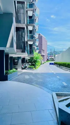 an empty street in front of a tall building at Modern 1BR Condo w Balcony Near Central Phuket in Ban Na Khua