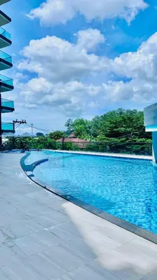 a large swimming pool with blue water at Modern 1BR Condo w Balcony Near Central Phuket in Ban Na Khua