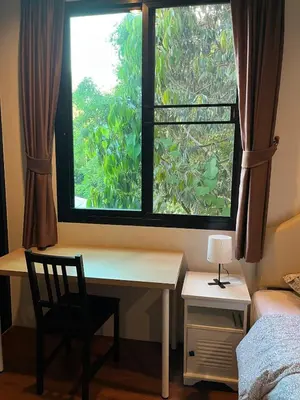 a bedroom with a desk and a window with a chair at Rawai Beach Villa in Nai Harn Beach
