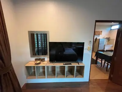 a flat screen tv sitting on top of a entertainment center at Rawai Beach Villa in Nai Harn Beach