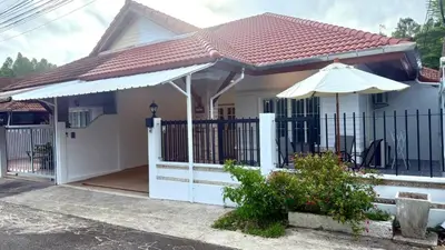 a house with a gate and an umbrella at Secret Valley near Phuket Town in Kathu
