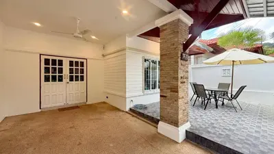 a home with a patio with a table and an umbrella at Secret Valley near Phuket Town in Kathu