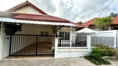 a house with a gate and an umbrella at Secret Valley near Phuket Town in Kathu