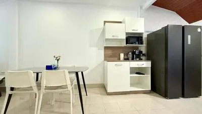 a dining room with a table and a black refrigerator at Secret Valley near Phuket Town in Kathu