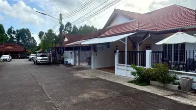 a white house with a gate and an umbrella at Secret Valley near Phuket Town in Kathu