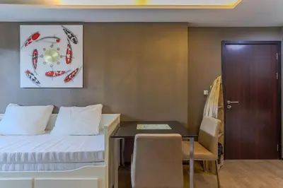 a hotel room with a bed and a desk and a door at C239 Best Spot Beachfront 1BR Near Top Beaches in Rawai Beach