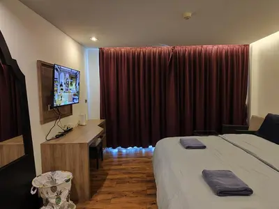 a hotel room with a bed and a flat screen tv at 4 Floor - Pool view Studio room at TBHR near Kata beach in Kata Beach