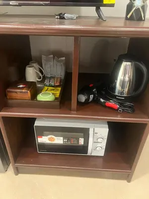 a shelf with a microwave and other items on it at SVAH Boutique Patong in Patong Beach