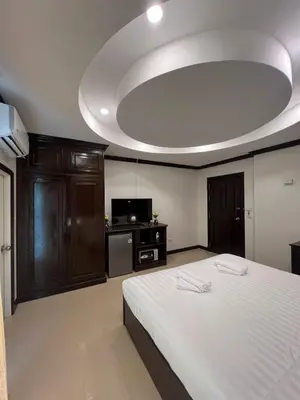 a bedroom with a large white bed and a tv at SVAH Boutique Patong in Patong Beach