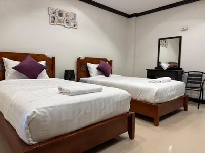 a bedroom with two beds and a mirror at SVAH Boutique Patong in Patong Beach