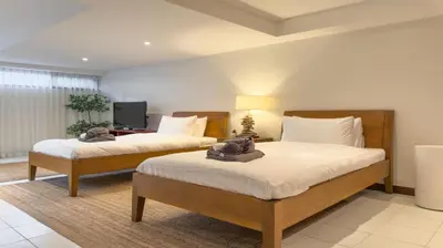 a bedroom with two beds and a television at Tropical Poolside Villa - SGB4 in Phuket Town