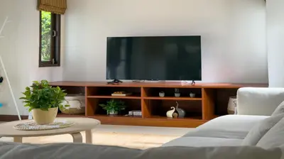 a living room with a flat screen tv on a entertainment center at Tropical Poolside Villa - SGB4 in Phuket Town