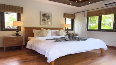 a bedroom with a large white bed and windows at Tropical Poolside Villa - SGB4 in Phuket Town